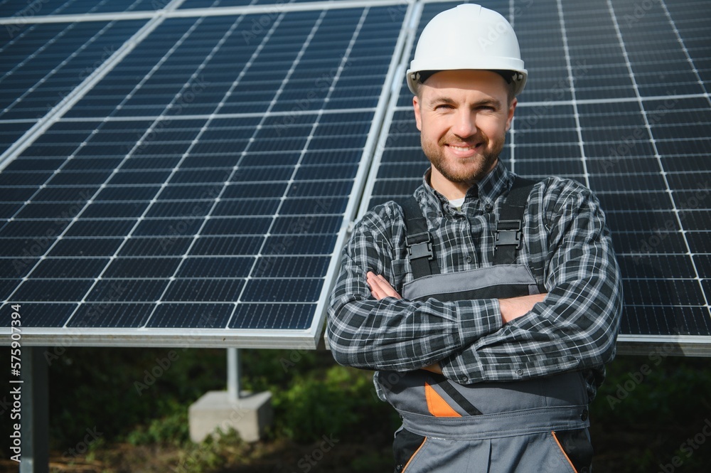 A handyman standing on the rooftop with solar panels and smiling at the camera. A handyman standing on the rooftop with solar panels and smiling at the camera.