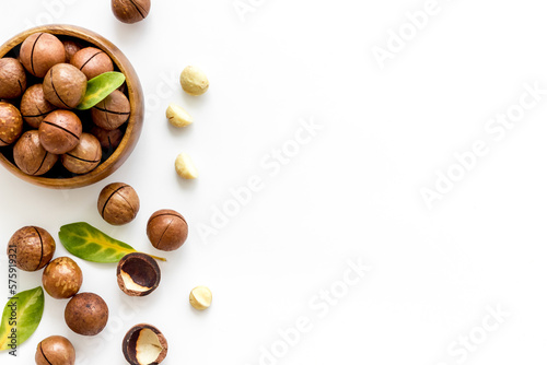 Flat lay of macadamia nuts in bowl, top view. Healthy food background