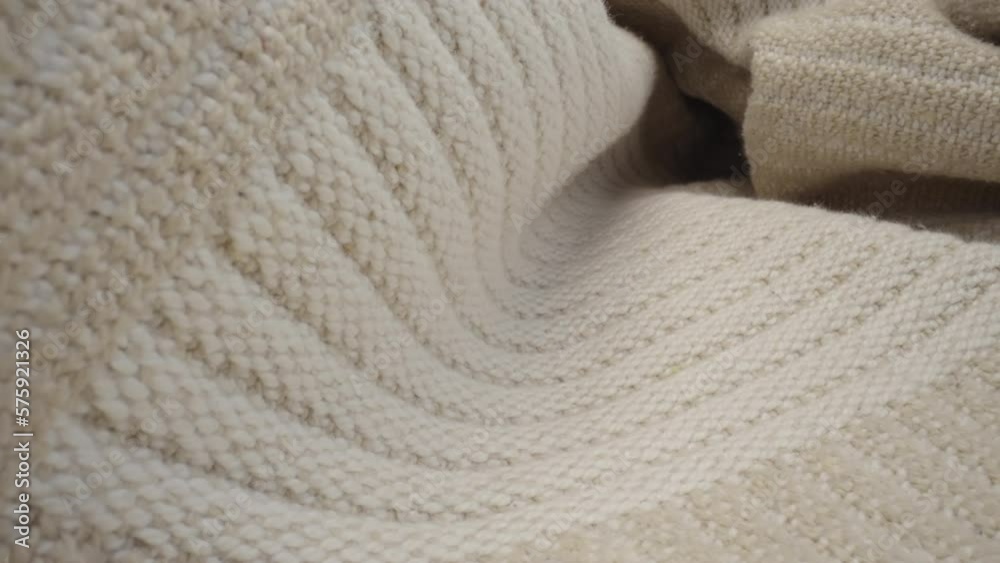Macro shot of patterned wool fabric. Slider dolly close-up plaid knitted textile beige color texture. Laowa probe lens camera glides over detailed knit cover material Macro shot of patterned wool fabric. Slider dolly close-up plaid knitted textile beige color texture. Laowa probe lens camera glides over detailed knit cover material