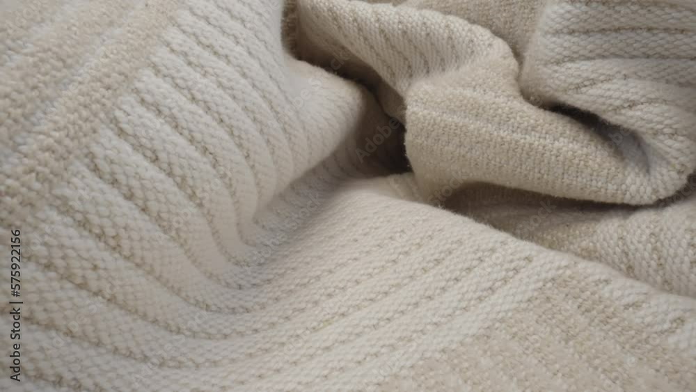 Macro shot of patterned wool fabric. Slider dolly close-up plaid knitted textile beige color texture. Laowa probe lens camera glides over detailed knit cover material