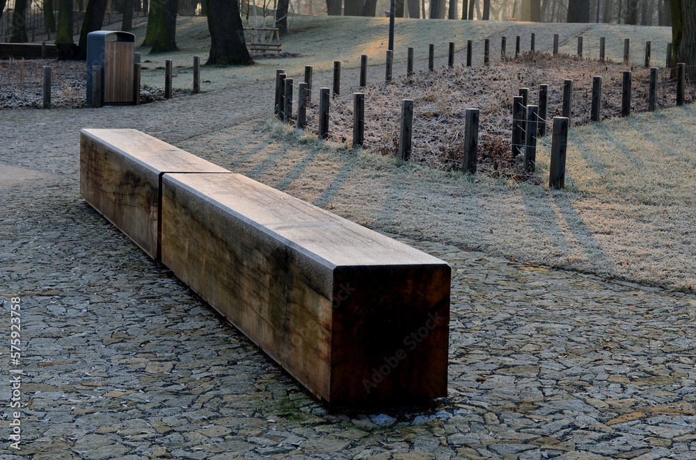 wooden oak prism bench in garden. for better drying of wood, grooves