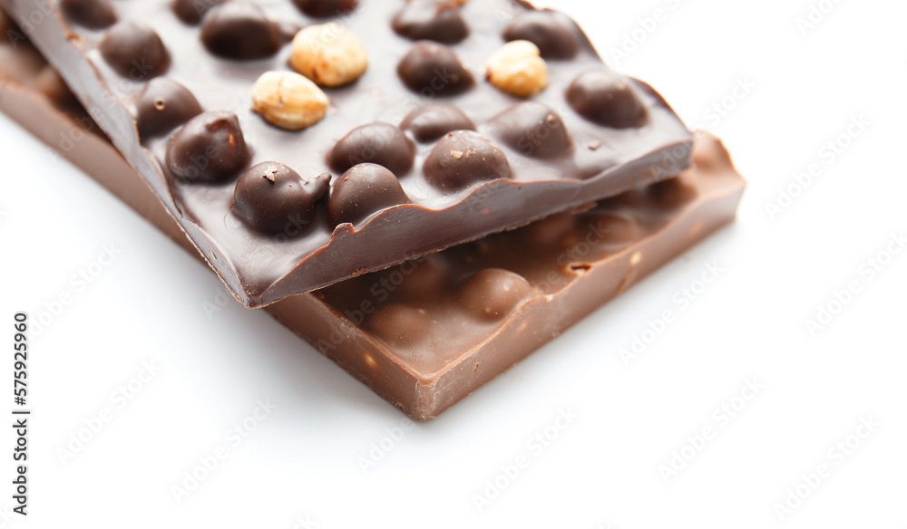 Black and milk chocolate with hazelnuts on a white background Black and milk chocolate with hazelnuts on a white background