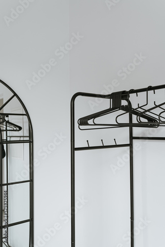 Hangers on floor hanger over white wall. Minimal home wardrobe interior concept