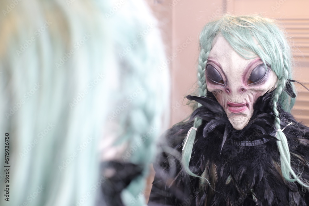Spooky female alien looking at her reflection 