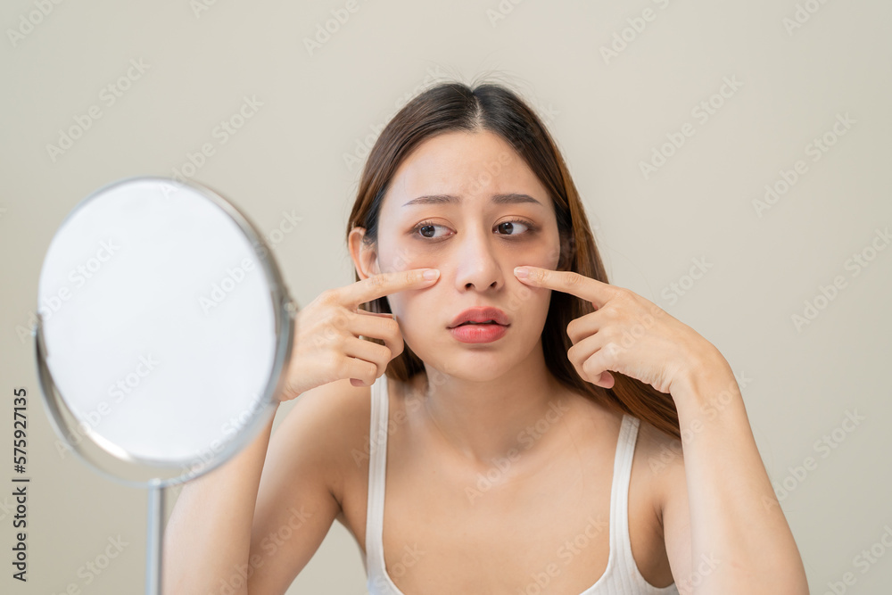 lack of sleep problem, Worried Asian young woman pointing finger at dark circles under her eyes lack of sleep problem, Worried Asian young woman pointing finger at dark circles under her eyes