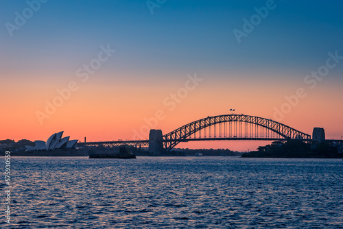 Sydney Harbor Bridge and Opera House during Sunset seen from the Sea, New South Wales, Australia.
