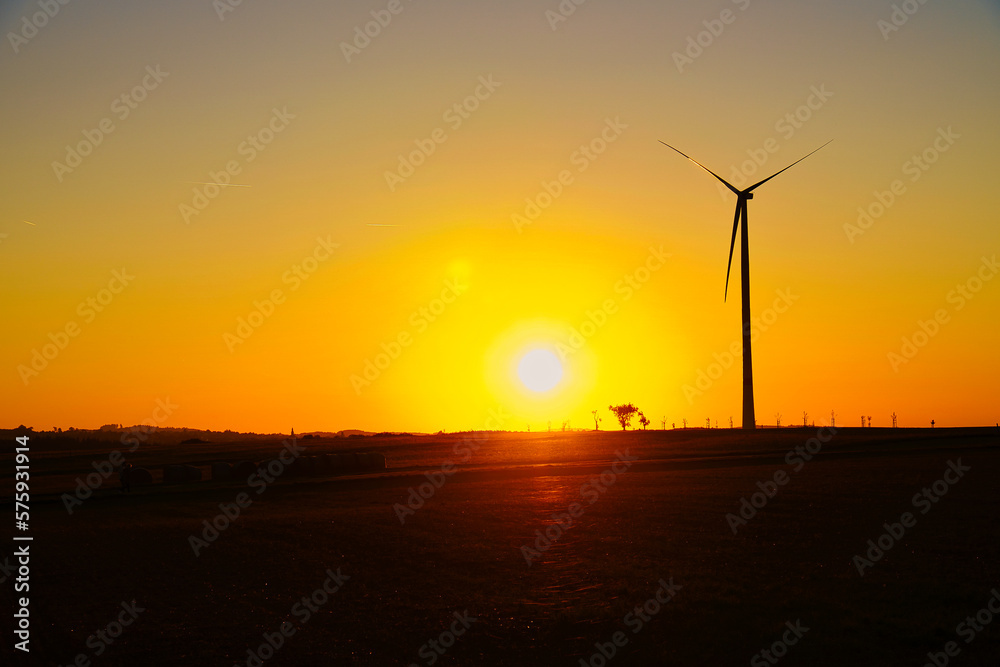 onshore wind turbine on a meadow at sunset. Renewable energy. Clean electricity