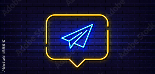 Neon light speech bubble. Paper plane line icon. Airplane flight transport sign. Share symbol. Neon light background. Paper plane glow line. Brick wall banner. Vector