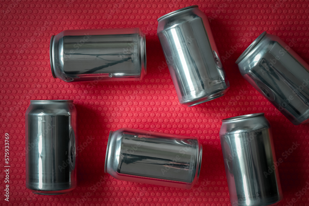 Empty aluminum cans on a bright pink background. Beverage containers. Top view.