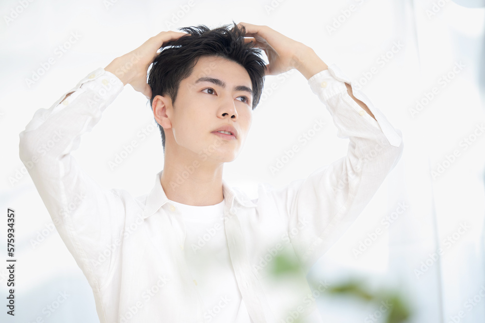 Naklejka premium 美容系のヘアセットやシャンプーなど髪の毛のイメージに使えそうな男性のポーズ