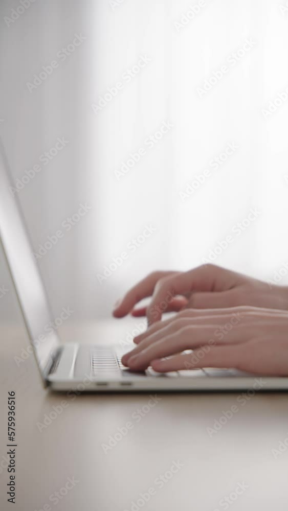 Closeup of hands typing on laptop keyboard with copy space.