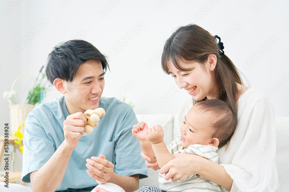 家で赤ちゃんと遊ぶ両親