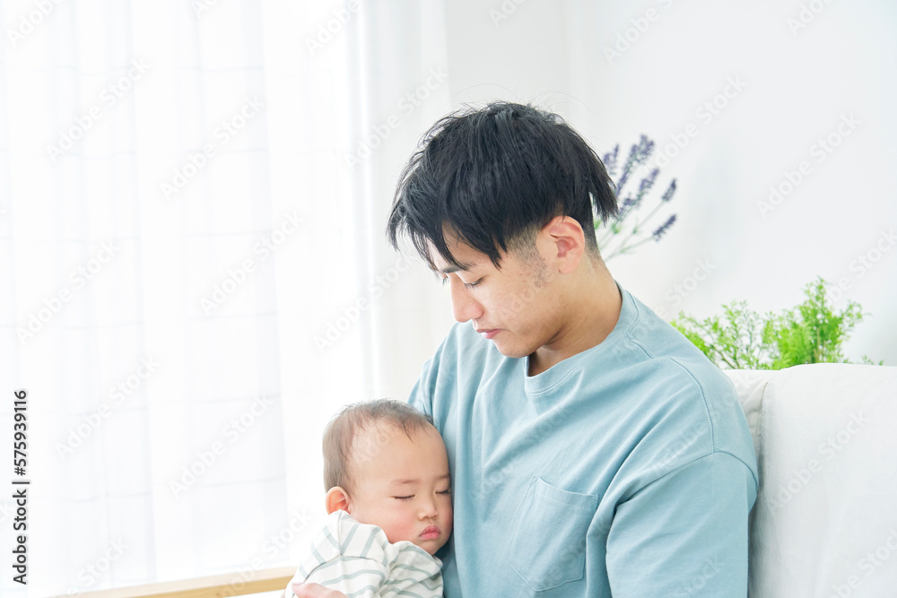 家で昼寝をする赤ちゃんを抱っこする父親 家で昼寝をする赤ちゃんを抱っこする父親