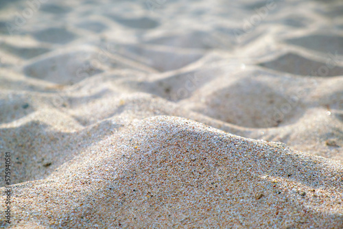Close up of clean yellow sand surface covering seaside beach illuminated with day light. Travel and vacations concept
