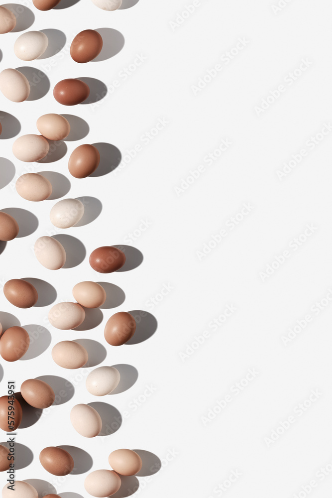 Easter eggs layout with beige gradient colored eggshell, hard Shadow at sunlight, white background with copy space. Chicken eggs layout, top view, minimal flat lay, holiday food still life Easter eggs layout with beige gradient colored eggshell, hard Shadow at sunlight, white background with copy space. Chicken eggs layout, top view, minimal flat lay, holiday food still life