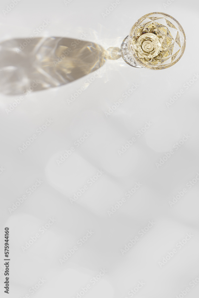 Top view of wineglass with white wine with beautiful shadows and reflections at sunlight, summer alcohol drink background, creative aesthetic table view, copy space, trend wine glass Top view of wineglass with white wine with beautiful shadows and reflections at sunlight, summer alcohol drink background, creative aesthetic table view, copy space, trend wine glass