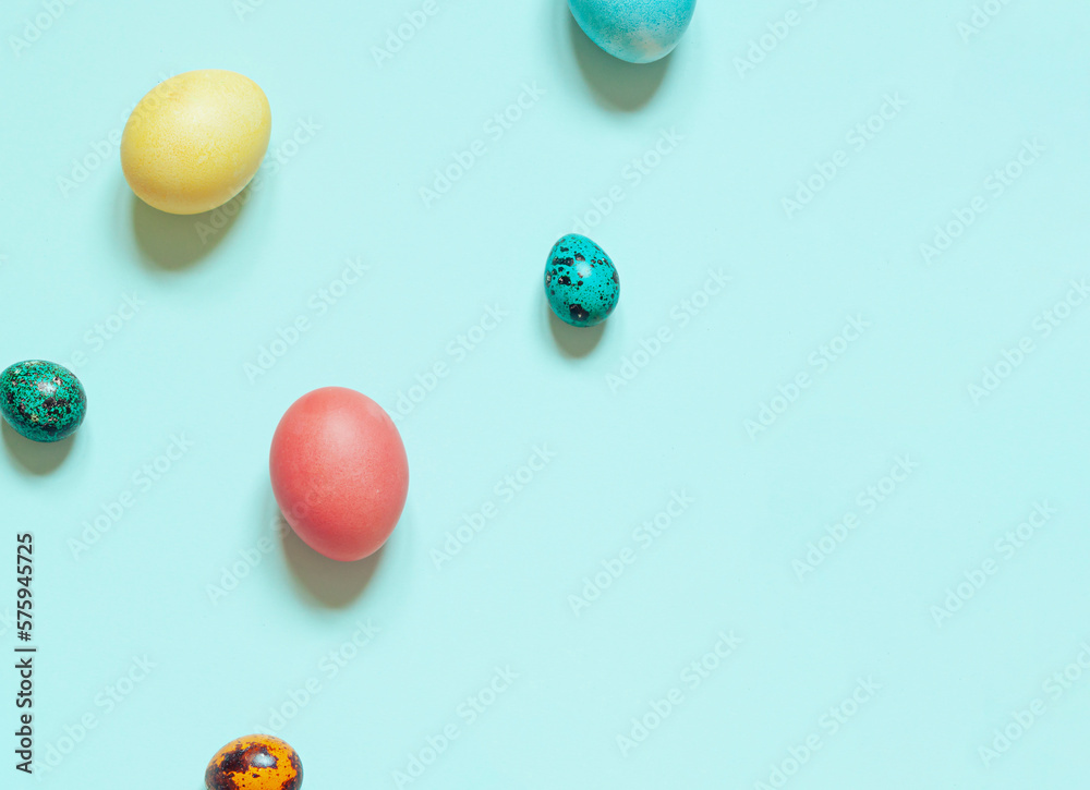 Colorful painted Easter eggs on the blue background. Top view. Copy space