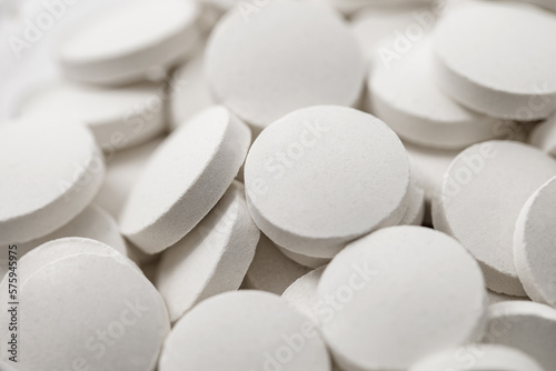 Tablets round white medical many in bulk, selective focus