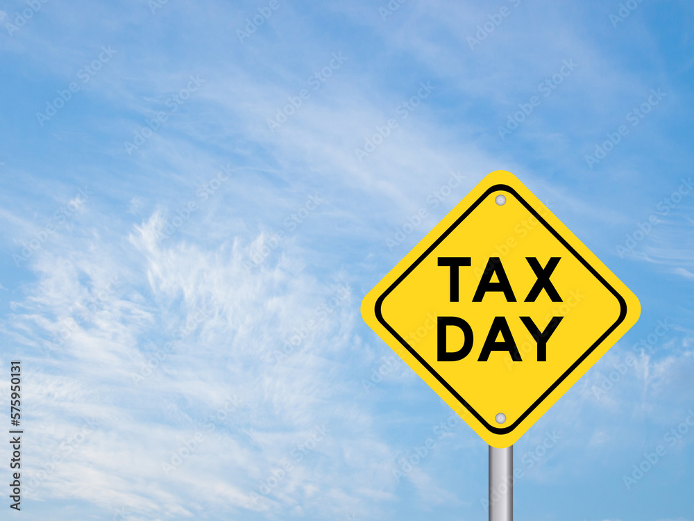 Yellow transportation sign with word tax day on blue color sky background Yellow transportation sign with word tax day on blue color sky background