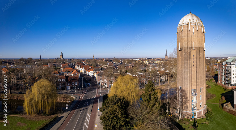 Panorama aerial of former Dutch brick water tower in Zutphen now repurposed as a residential home with asphalt road next to it. Architectural detail Dutch infrastructure engineering fresh water system