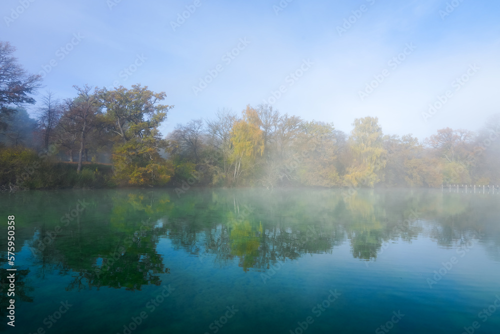 Autumn landscape by the lake. Nature with fog in the morning.
