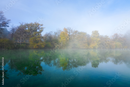 Autumn landscape by the lake. Nature with fog in the morning. 