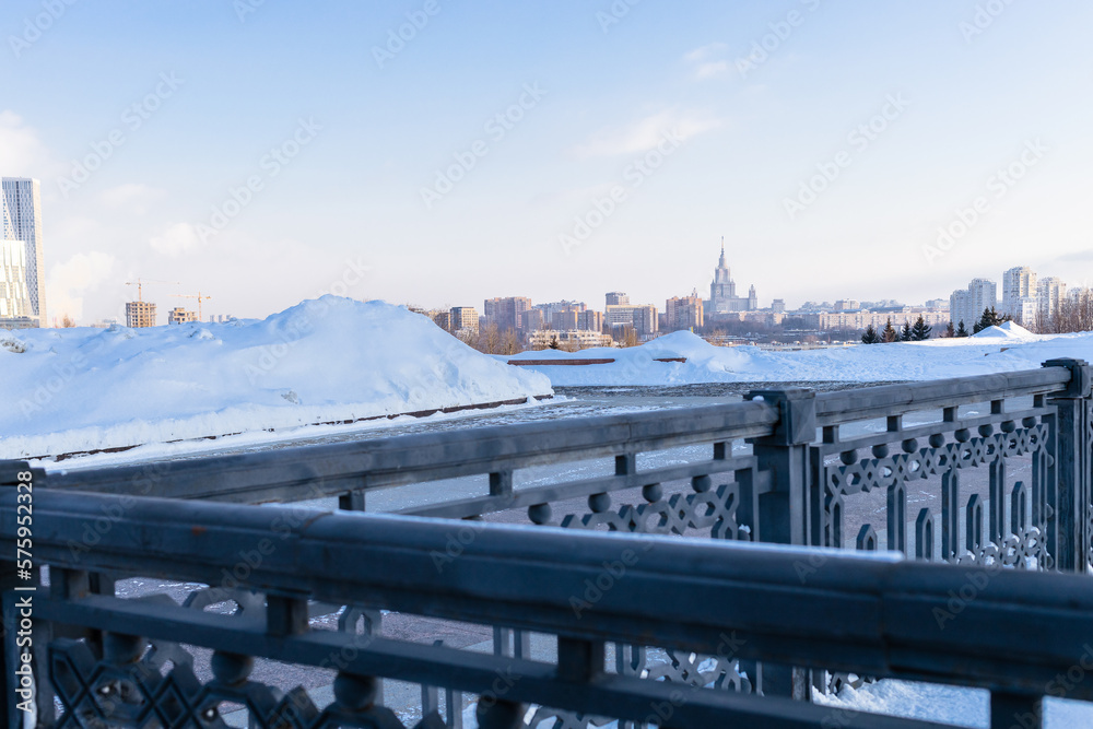 view of fence and Moscow skyline from Pobediteley Square on Poklonnaya Gora on sunny winter day