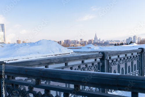 view of fence and Moscow skyline from Pobediteley Square on Poklonnaya Gora on sunny winter day