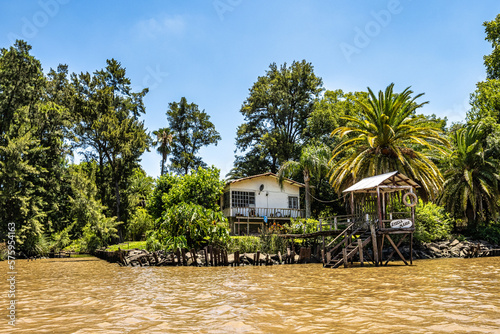 Boat tour on the Parana Delta, Tigre, Buenos Aires, Argentina. Palm trees, construction site of modern brick house. photo