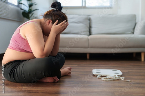 Stressful Asian overweight woman sad of dieting Weight loss fail.. photo