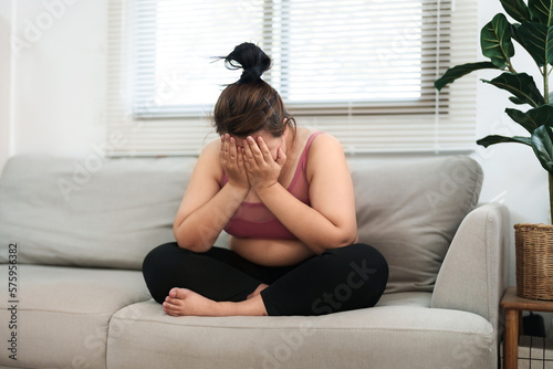 overweight woman sitting on the sofa stress about loss weight.. photo