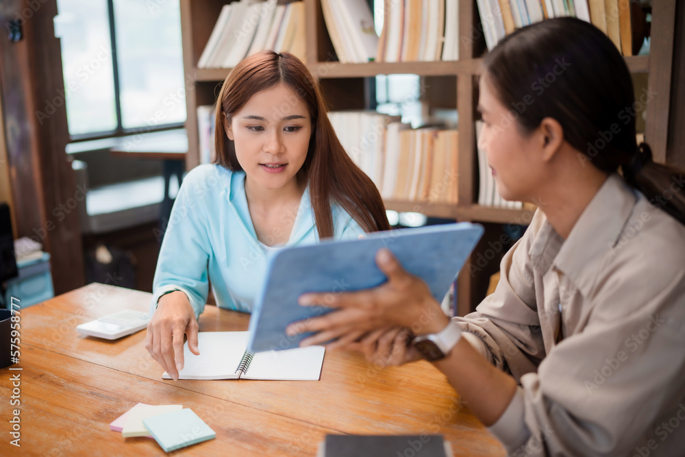Asian student girl High School Tutor Individual Tuition From Teacher In Library. University Student Tutor books with friends. Asian student girl High School Tutor Individual Tuition From Teacher In Library. University Student Tutor books with friends.