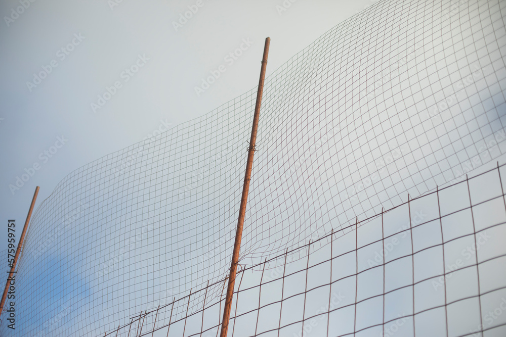 High fence. Steel mesh in stadium. Fence from ball. High fence. Steel mesh in stadium. Fence from ball.