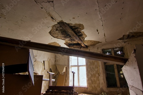 Abandoned place Residential house: Dark room with light window and collapsed ceiling and old junk.