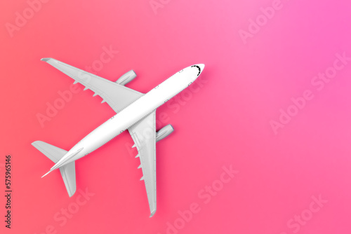 Airplane on a pink background, flat lay, travel concept.