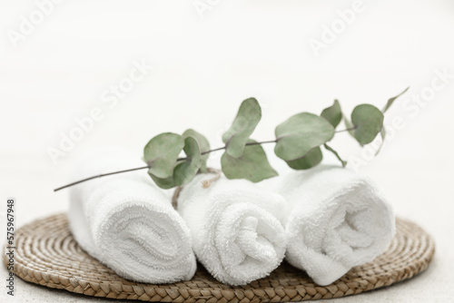 Spa composition with white towels and a sprig of eucalyptus.
