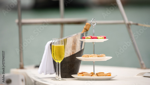 Rich man sleep lying in yacht ship for eat Afternoon tea and champagne . yachting man relax with cake stand decorate catering banquet services with champagne in sea and sunlight