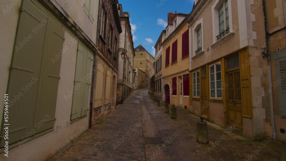 Classic medieval French facades of houses and hotels in the center of the old city not far from Paris against the backdrop of a blue sky and blue clouds. Colored buildings of old houses in France Classic medieval French facades of houses and hotels in the center of the old city not far from Paris against the backdrop of a blue sky and blue clouds. Colored buildings of old houses in France