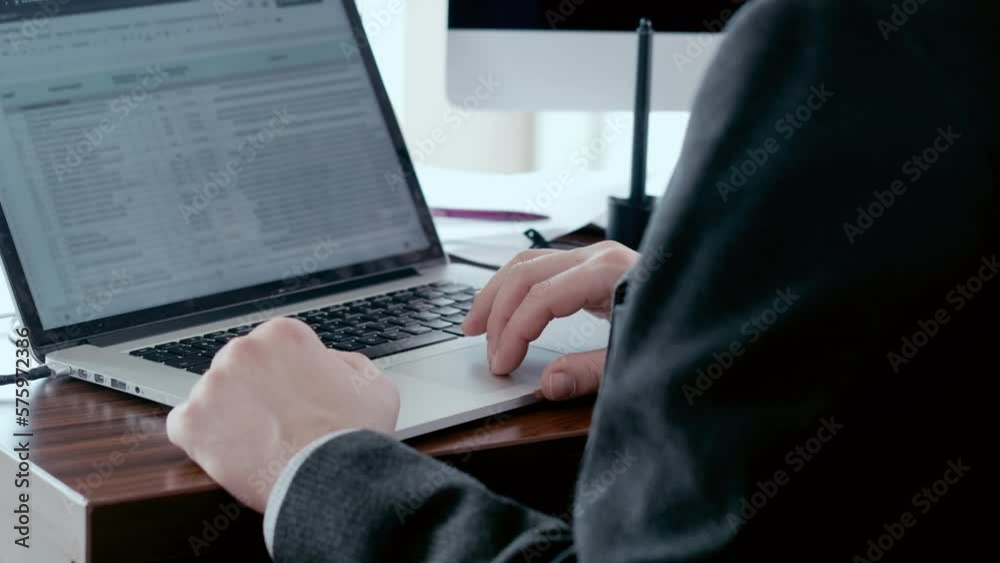 Man in suit typing on a laptop keyboard, working in office. Business analytics in bank sphere, daily report. Man in suit typing on a laptop keyboard, working in office. Business analytics in bank sphere, daily report.