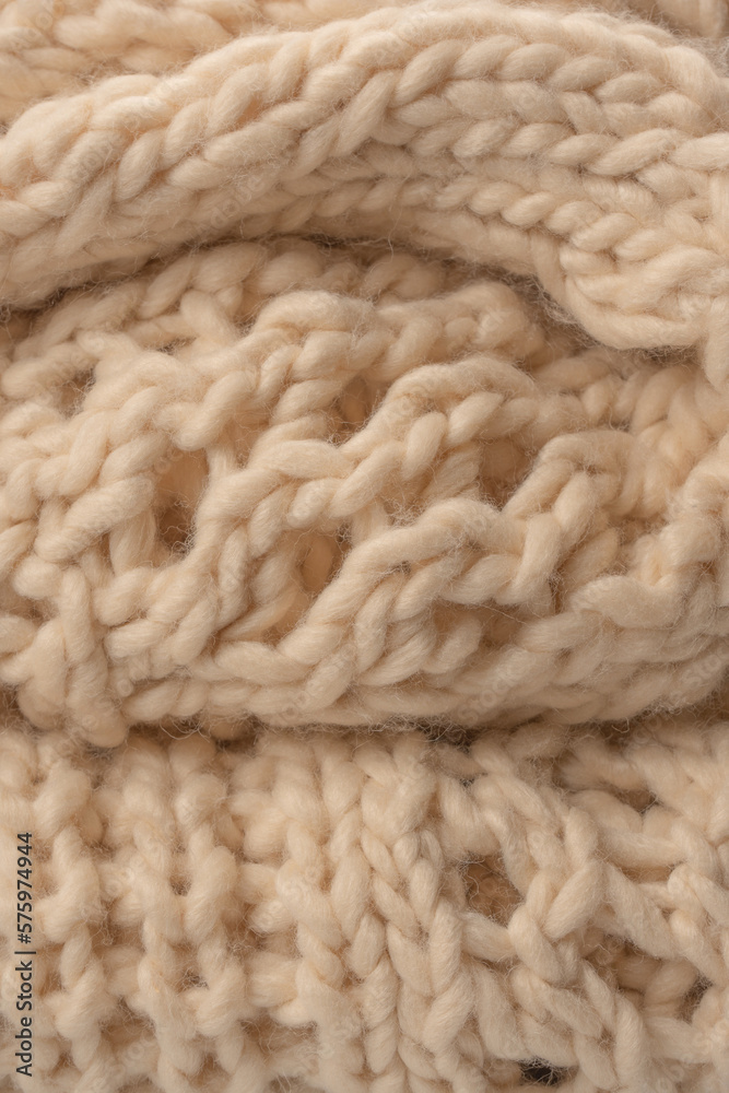A fragment of beige knitted fabric, knitted from white sheep wool. A fragment of beige knitted fabric, knitted from white sheep wool.