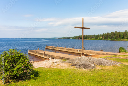 church cross on a rock on a lakeshore