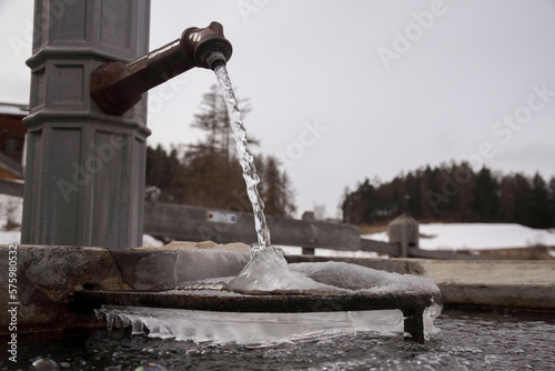 water splashes into a frozen fountain in the Swiss Alps