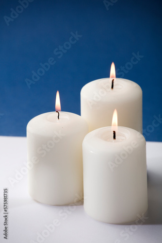 three burning candles on a blue background