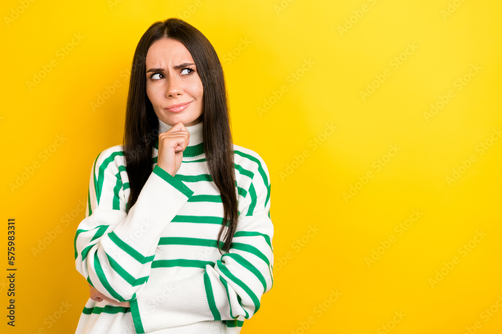 Photo of doubtful funny woman wear striped sweater arm chin looking empty space isolated yellow color background