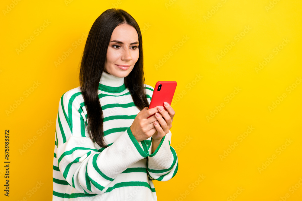 Photo of pretty sweet woman wear striped sweater communicating modern device empty space isolated yellow color background Photo of pretty sweet woman wear striped sweater communicating modern device empty space isolated yellow color background