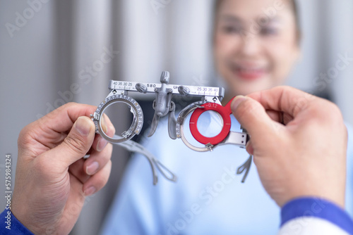 Selective focus, Optometrist gives experimental frame optical device to senior woman for vision test