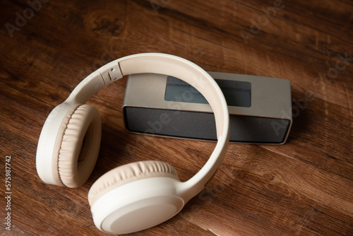 A wireless over ear headphone and speaker on the table 