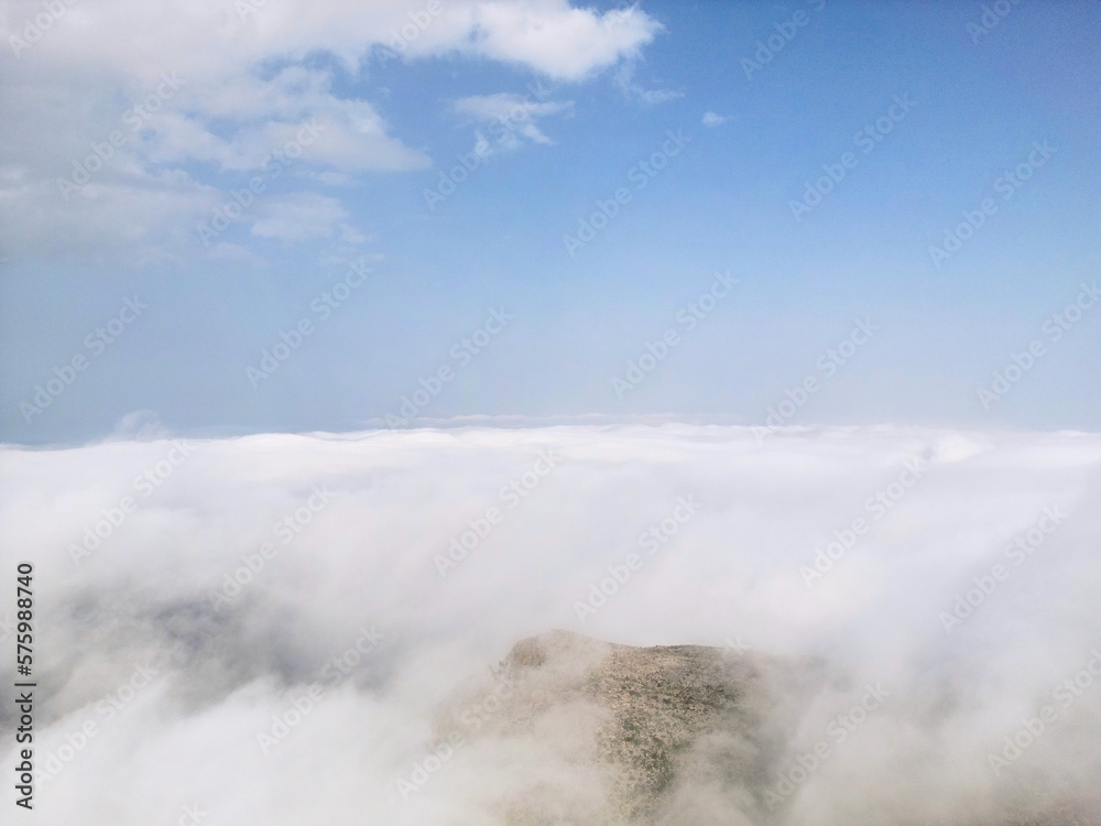 Flying above the clouds on drone.Drone soars through thick clouds, revealing majestic mountain silhouettes. Calp, Alicante, Spain