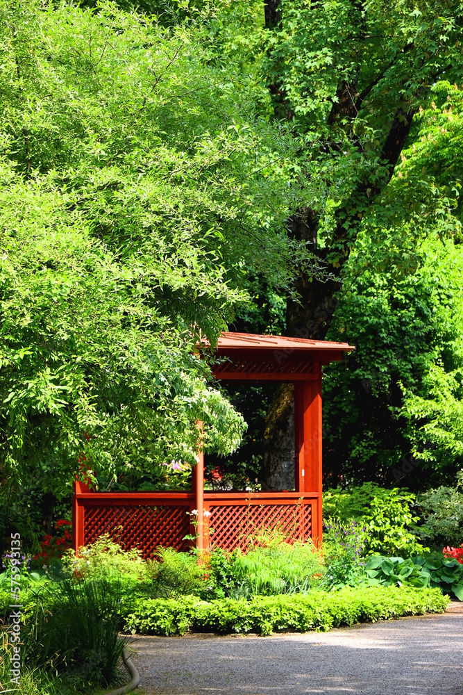 Red pavilion and lush green trees in the park. Red pavilion and lush green trees in the park.