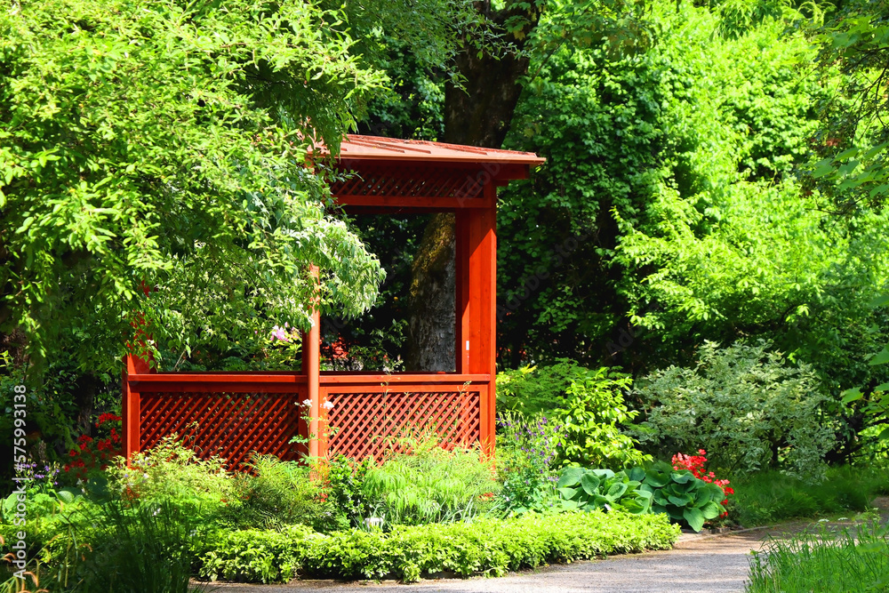 Red pavilion and lush green trees in the park. Red pavilion and lush green trees in the park.